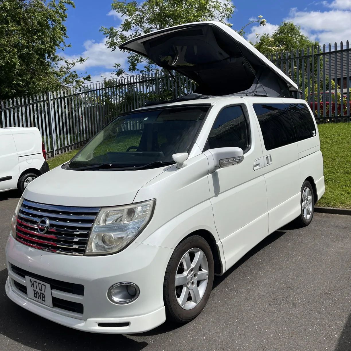 White Nissan Elgrand with pop-top roof raised