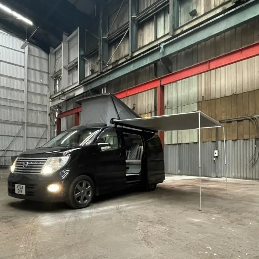 Black Nissan Elgrand campervan with side awning